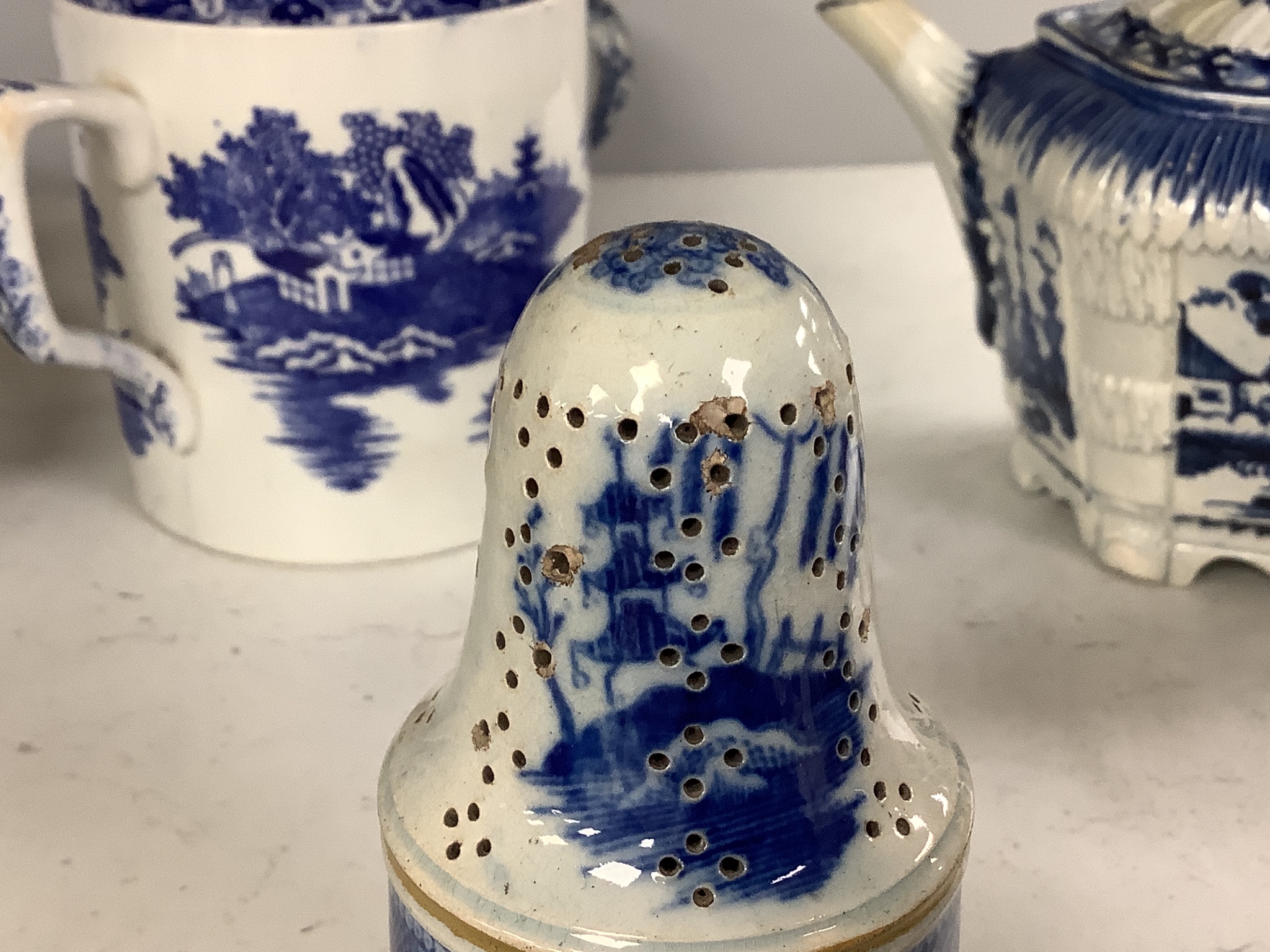A collection of English blue and white pottery, various dates, comprising a moulded hexagonal teapot and cover, with widow finial, ovoid teapot and cover, lozenge section sugar bowl and cover, with swan finial, circular